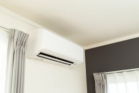 Intérieur résidentiel moderne avec climatiseur split mural blanc installé au plafond près d'une fenêtre