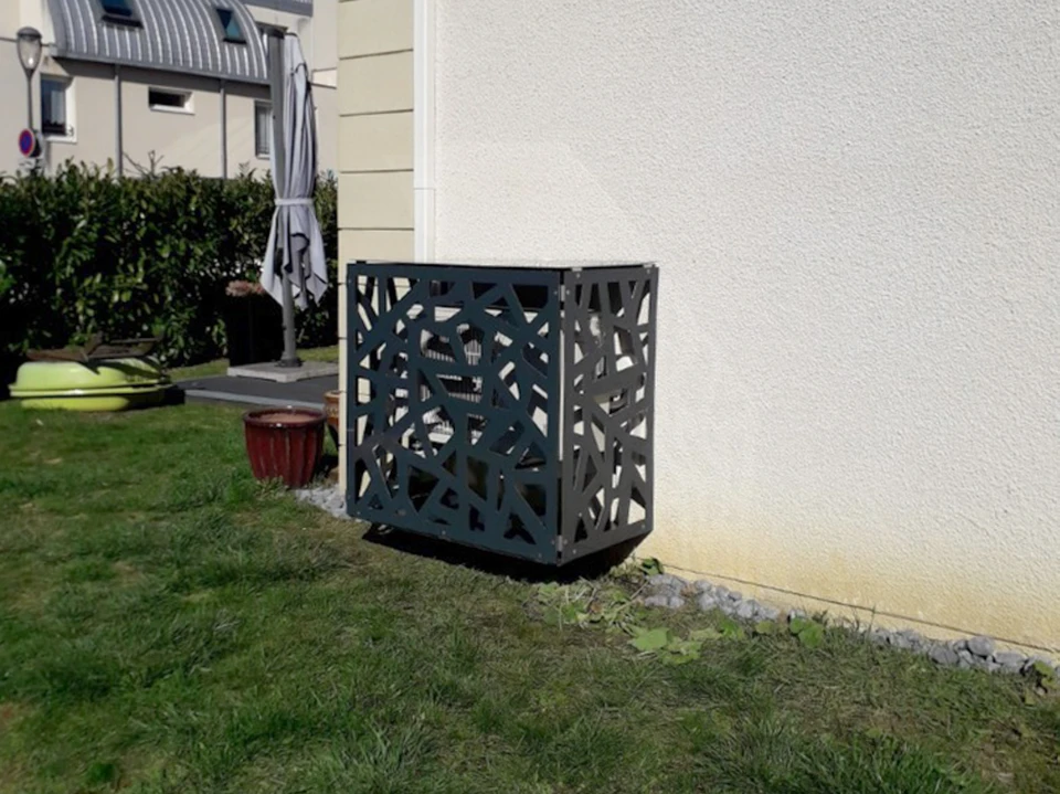 Un technicien en combinaison blanche et casquette installe ou répare un radiateur à eau chaude dans un intérieur résidentiel