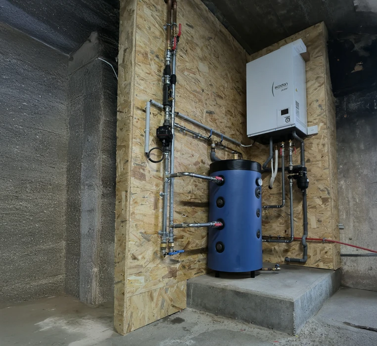 Intérieur d'une pièce avec parquet en bois partiellement installé, révélant le système de chauffage au sol en dessous