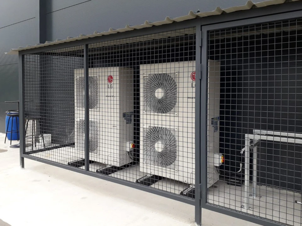 Extérieur résidentiel avec unité de climatisation/pompe à chaleur installée contre façade d'immeuble