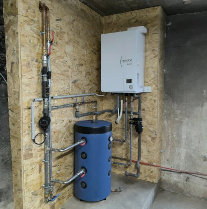 Salle de bain moderne avec carrelage gris clair, chauffe-eau électrique blanc cylindrique installé dans un angle