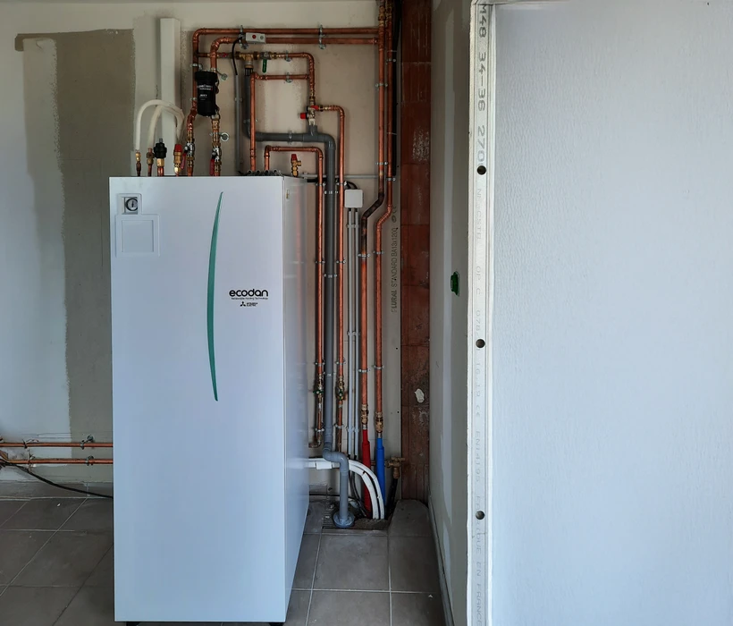 Sous-sol technique avec chauffe-eau électrique cylindrique blanc installé