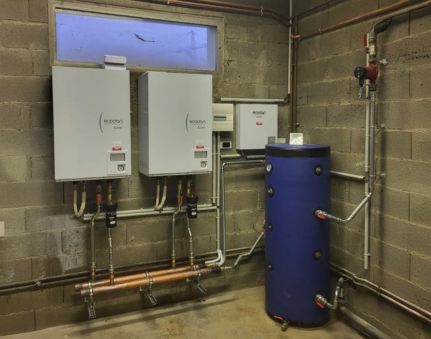 Local technique moderne avec chaudière murale blanche, vase d'expansion vert installé sur support métallique, collecteurs de chauffage avec vannes de régulation